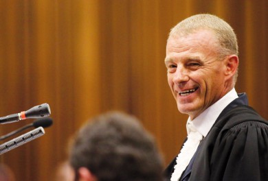 State prosecutor Nel smiles as he cross-examines South African Olympic and Paralympic sprinter Pistorius during his trial at the North Gauteng High Court in Pretori